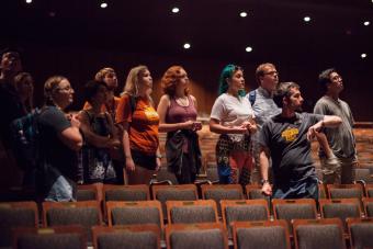 A group of Hook 'em Arts members stand in an empty Bass Concert Hall